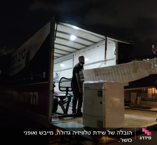 שני אנשים מעמיסים רהיטים למשאית בלילה